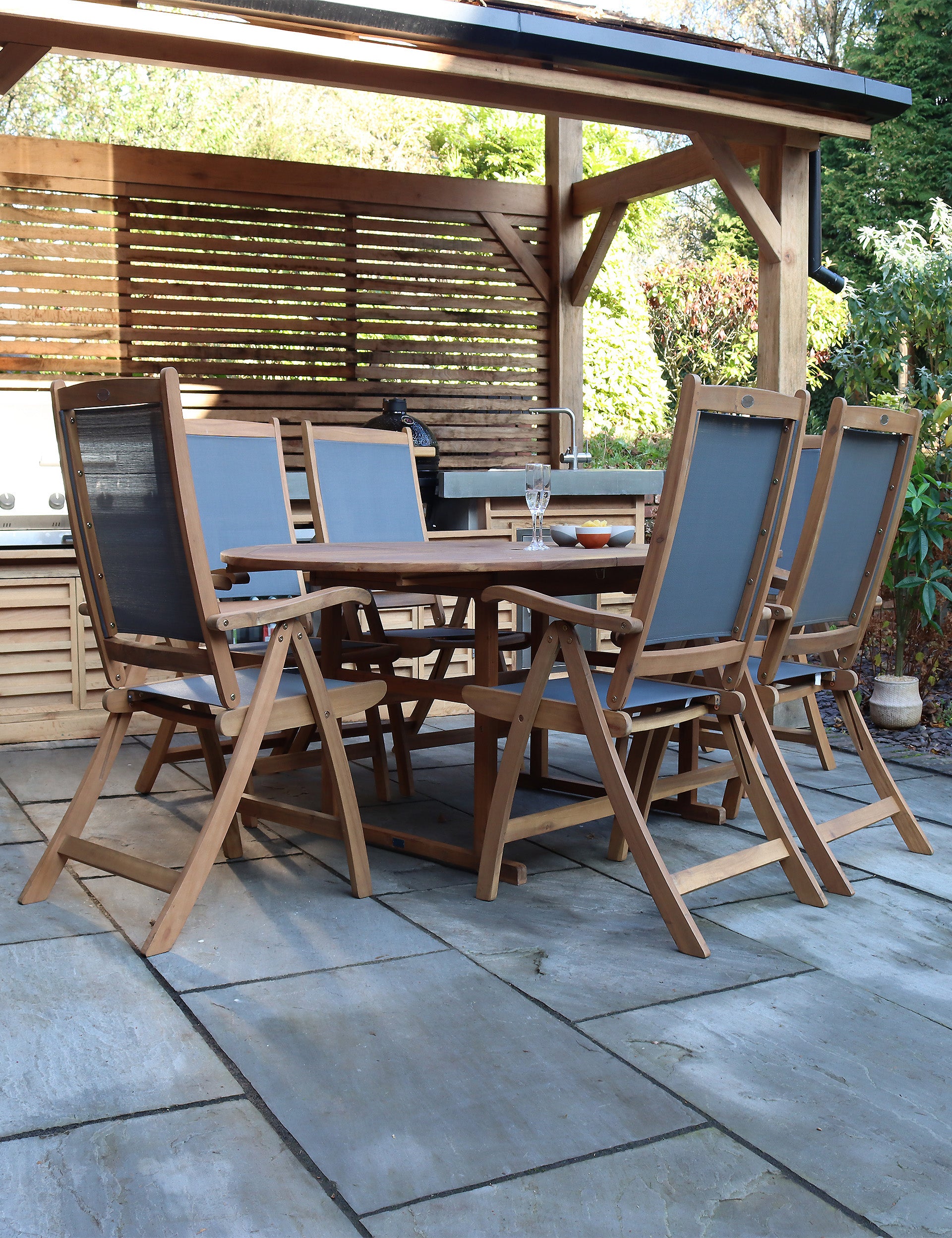 Wooden dining table with matching chairs outdoors on patio