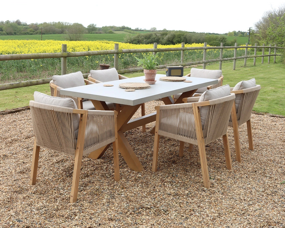 Outdoor dining set with grey rectangular table and six cushioned rope chairs