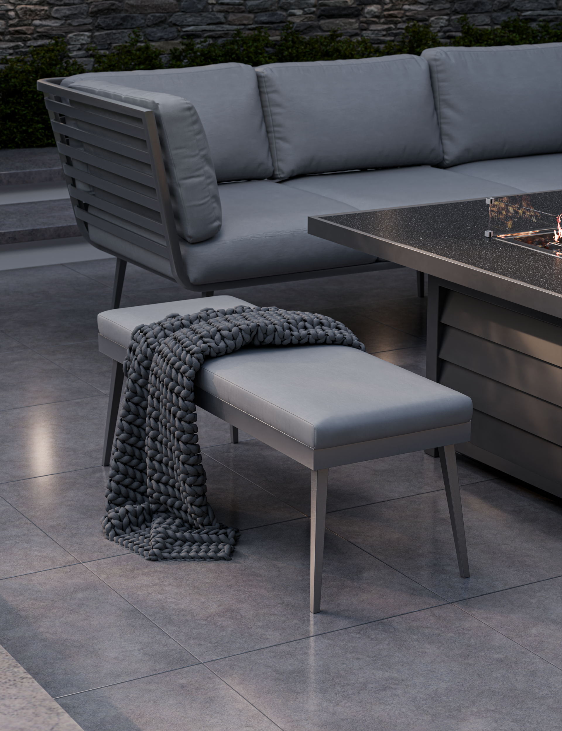 Close‑up of fire table and seating area with grey cushions