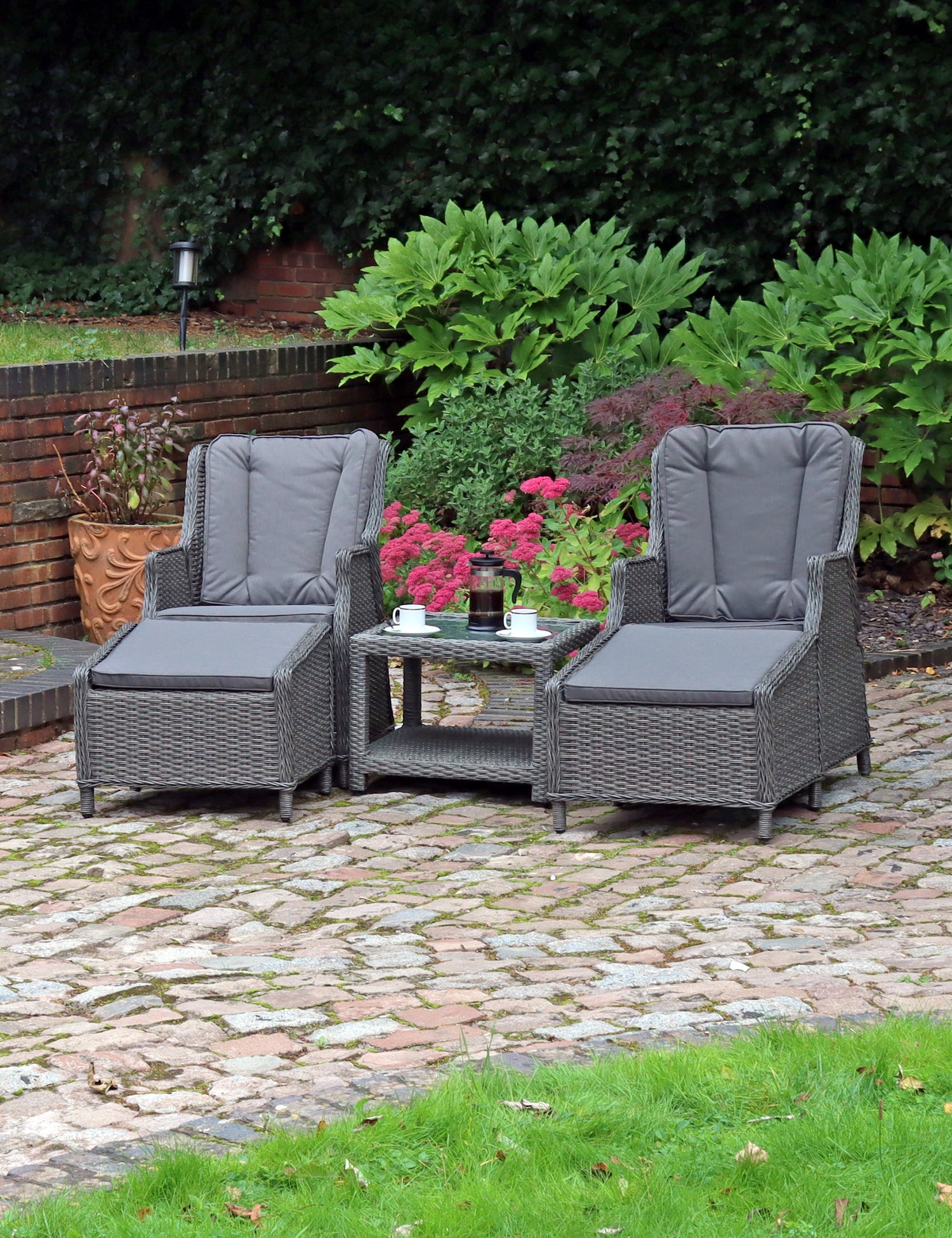 Grey rattan outdoor set with two cushioned chairs and table