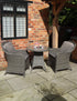 Grey rattan bistro set with round table and two cushioned chairs