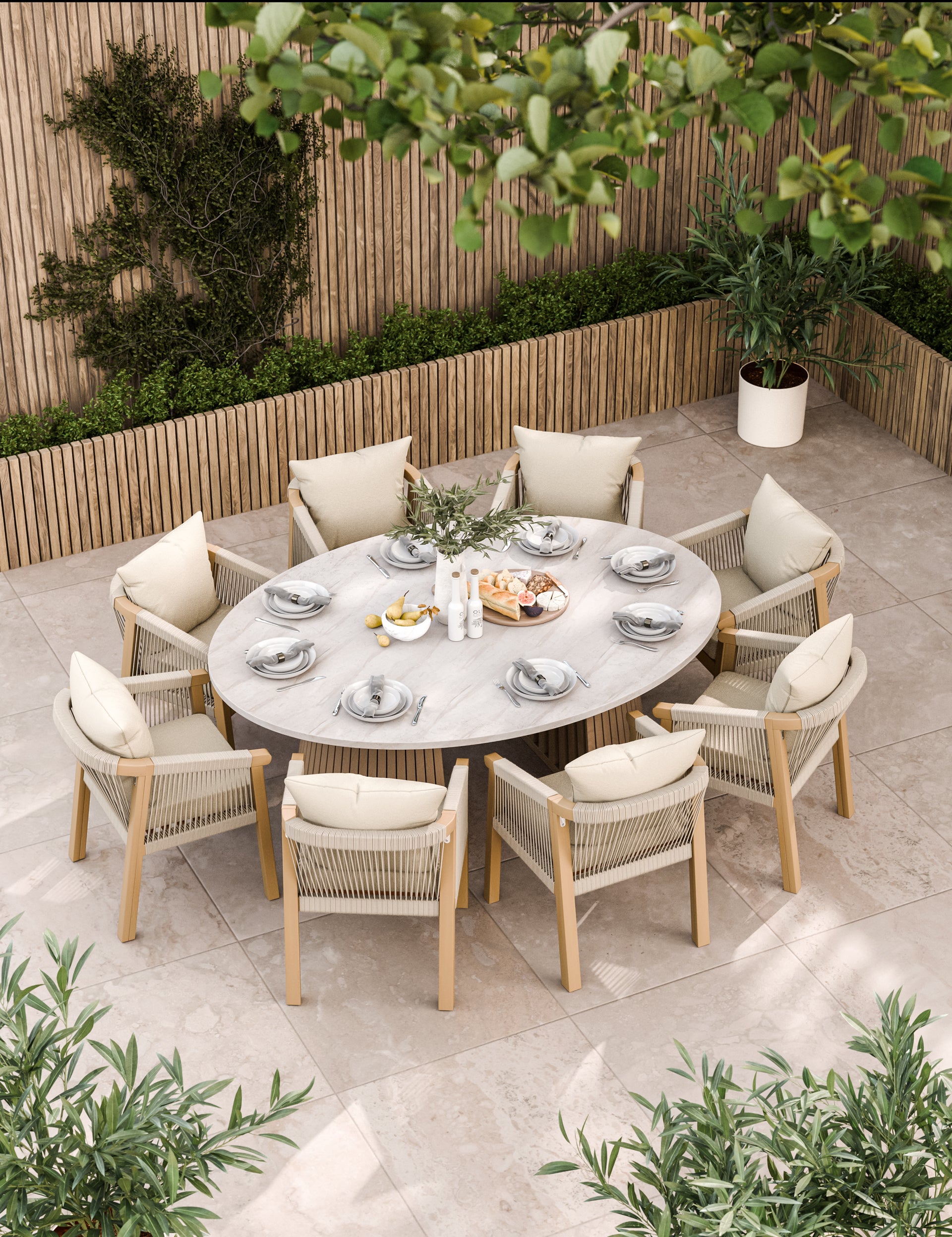 Large oval outdoor dining table with eight cream cushioned chairs