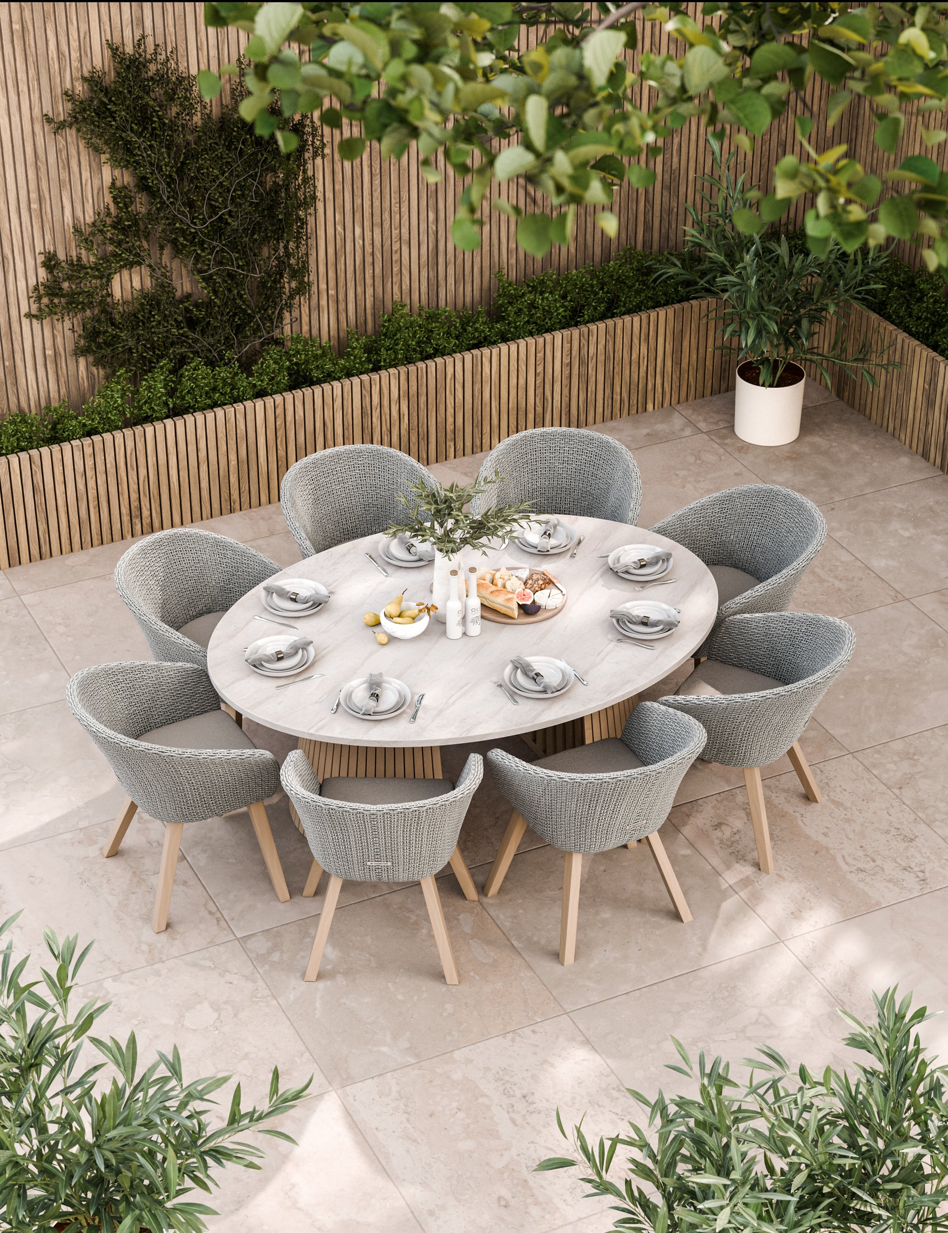 Large oval outdoor dining table with eight grey cushioned chairs