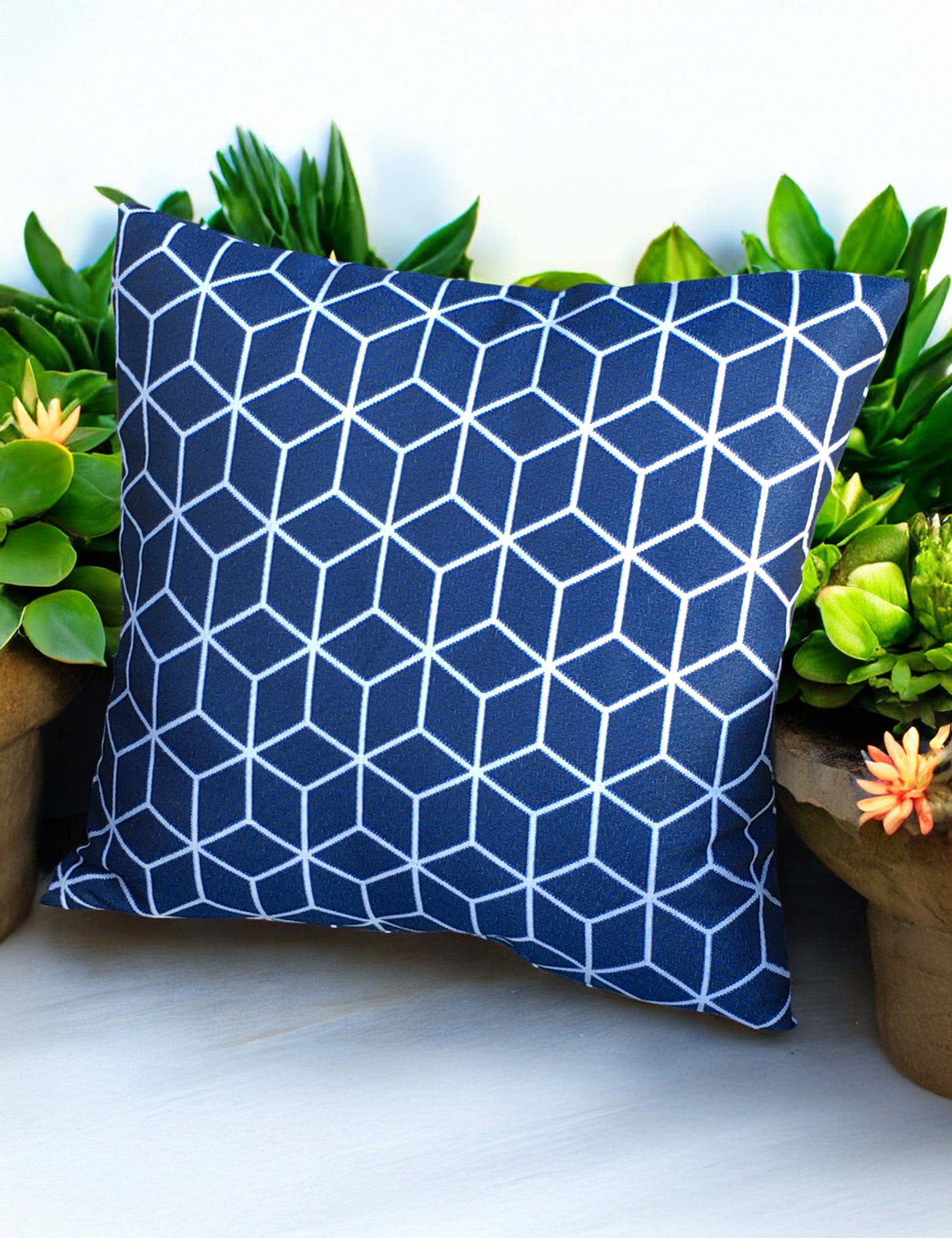 Blue outdoor cushion with white geometric cube pattern