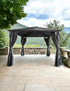 Black outdoor gazebo with curtains on a stone patio overlooking hills