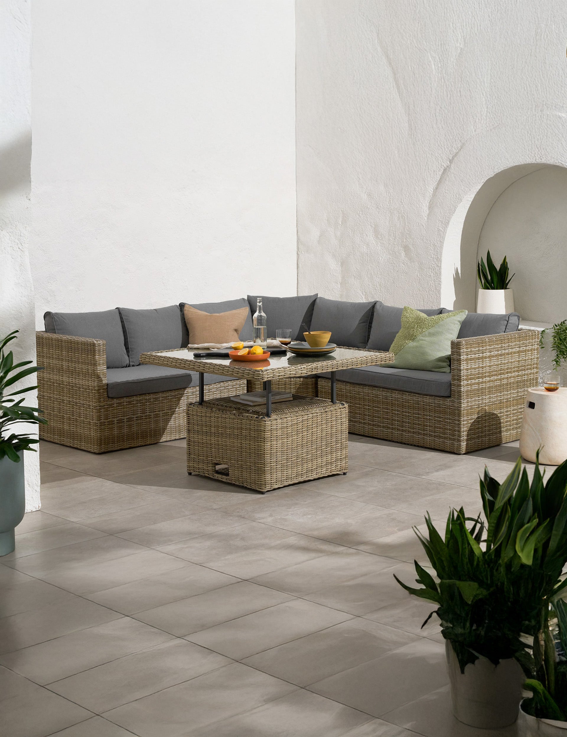 Rattan corner sofa set with grey cushions and coffee table on patio