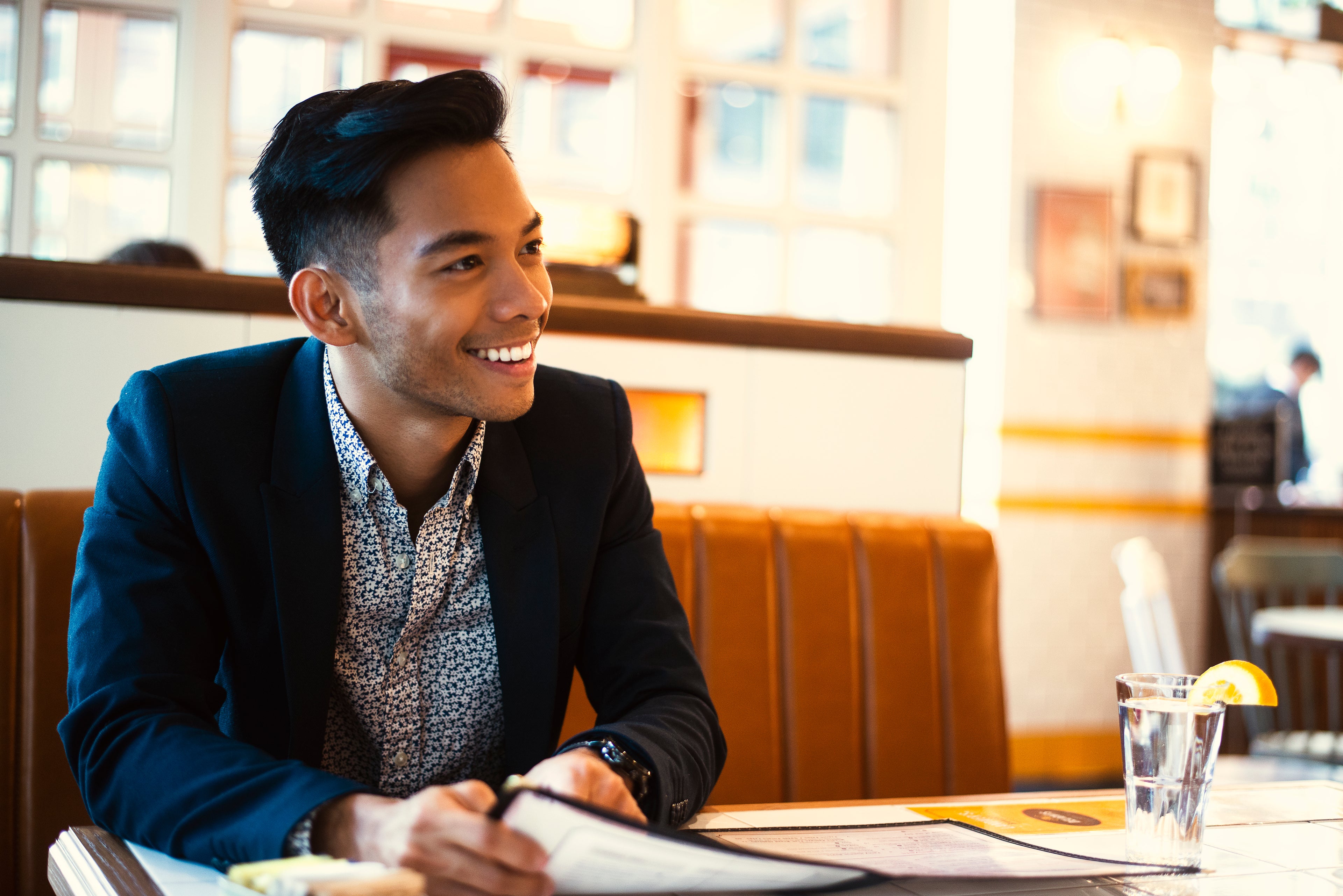 Person smiling across a table in a bright room