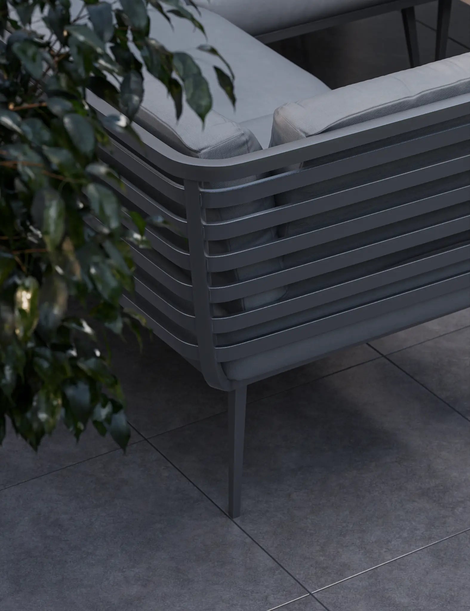 Image of Gray outdoor chair on a tiled patio with a plant in the background