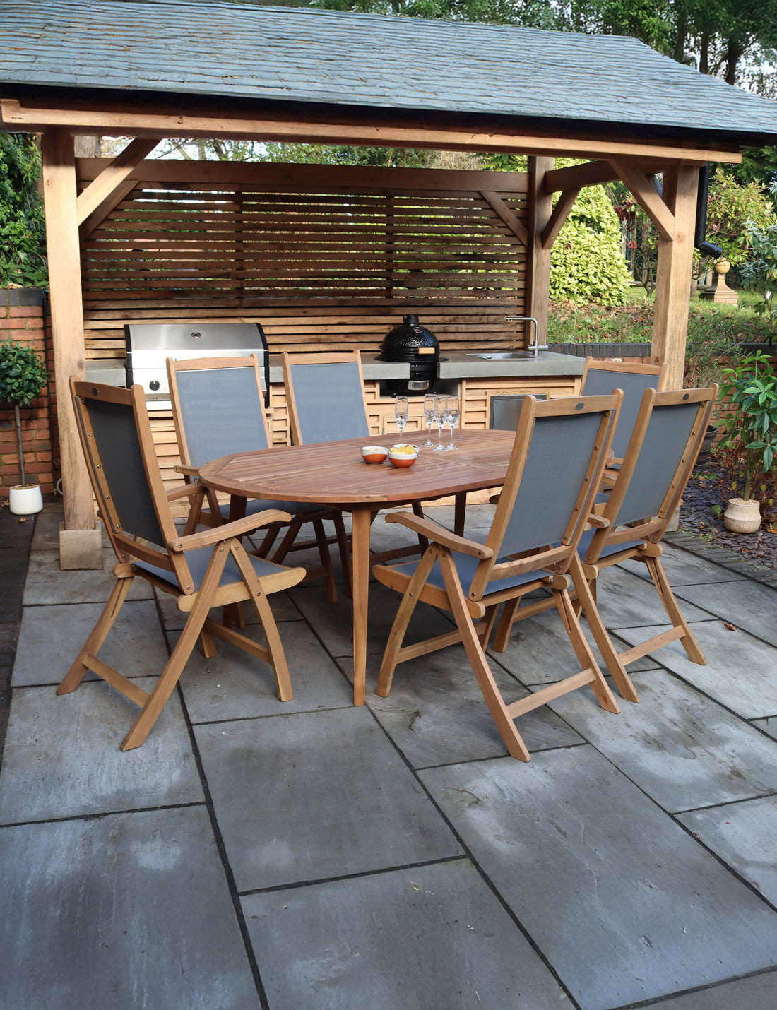 Wooden garden dining set with six chairs under pergola