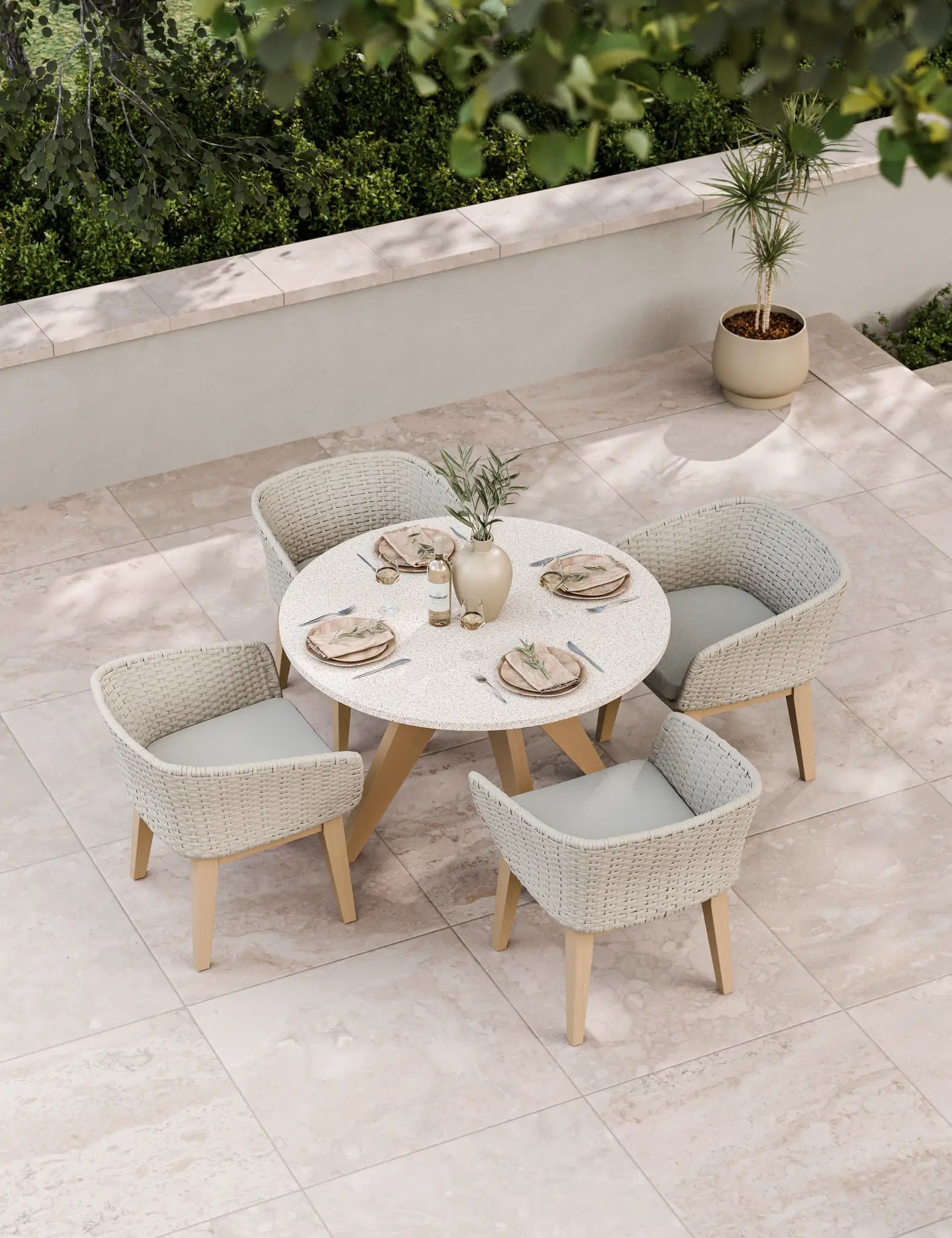 Round outdoor dining set with four wicker chairs