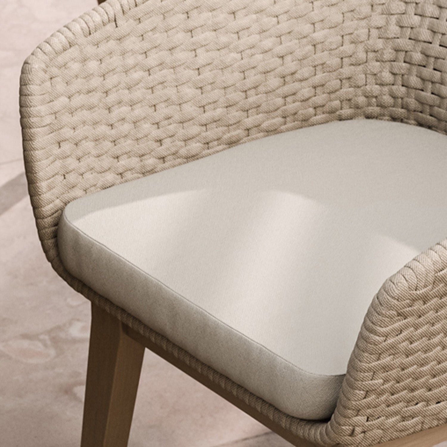 Image of Close-up of a woven chair with a cushioned seat on a neutral background