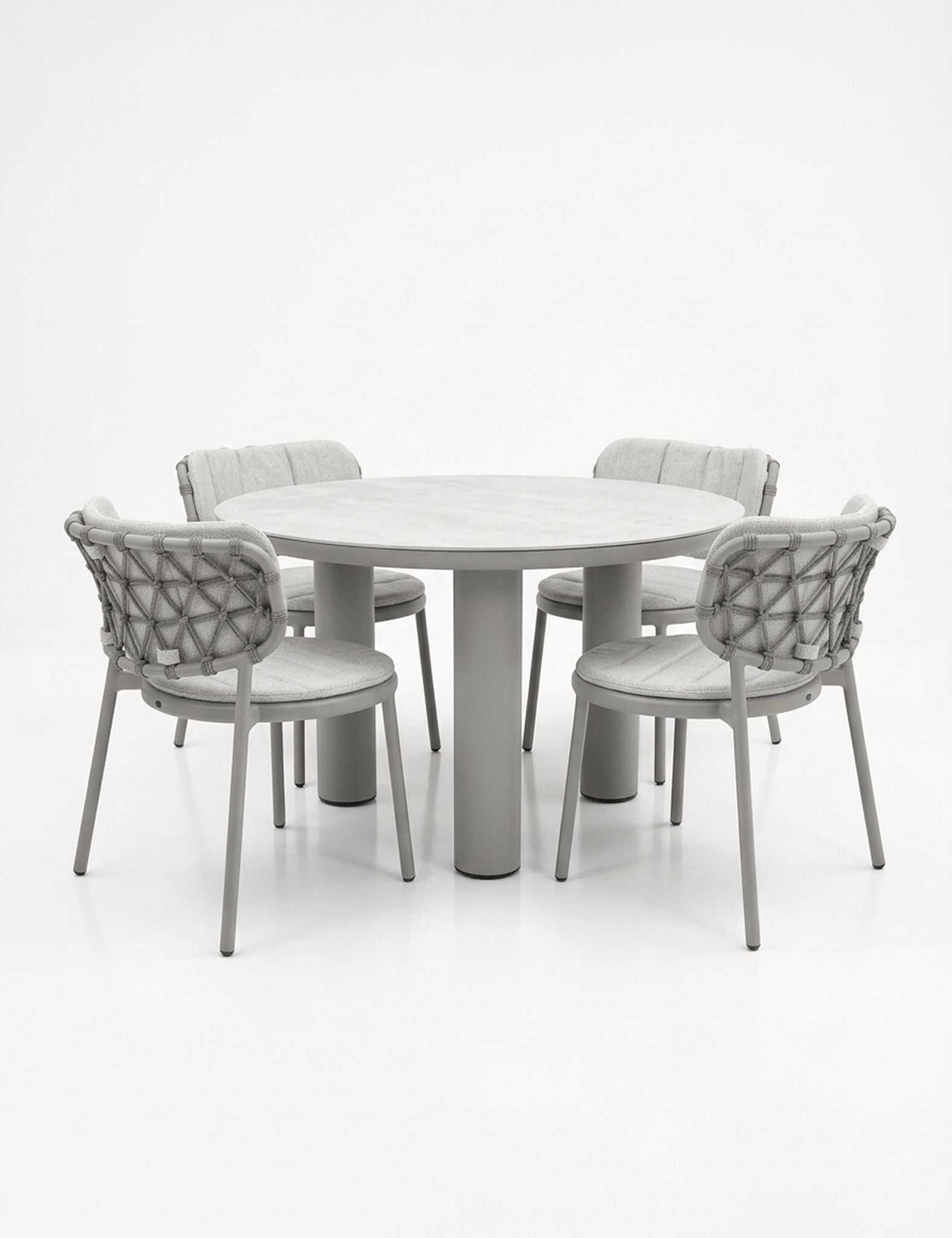 Image of Round dining table with four matching chairs on a white background