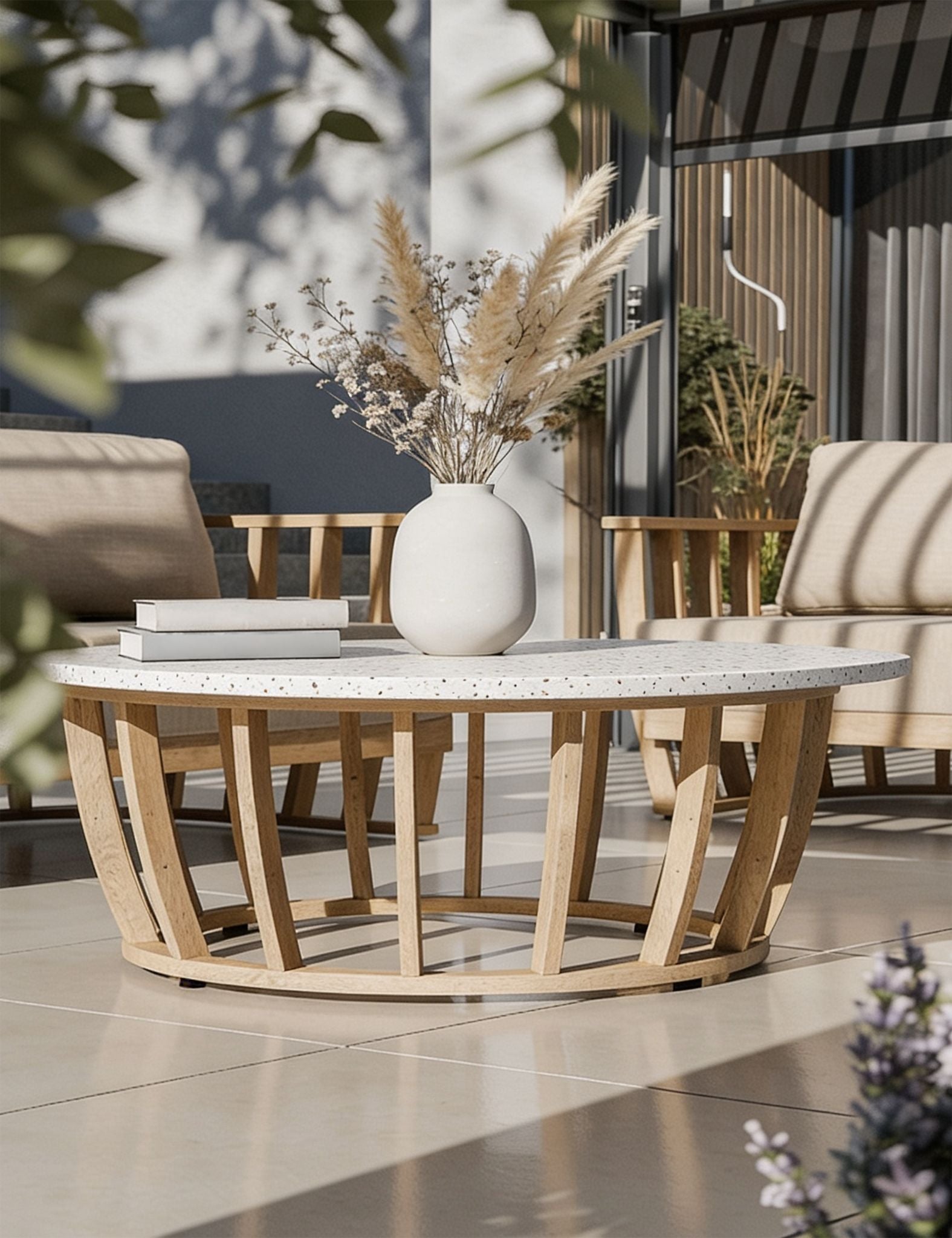 Image of Outdoor patio setting with a round wooden table and chairs, featuring a vase with dried plants.