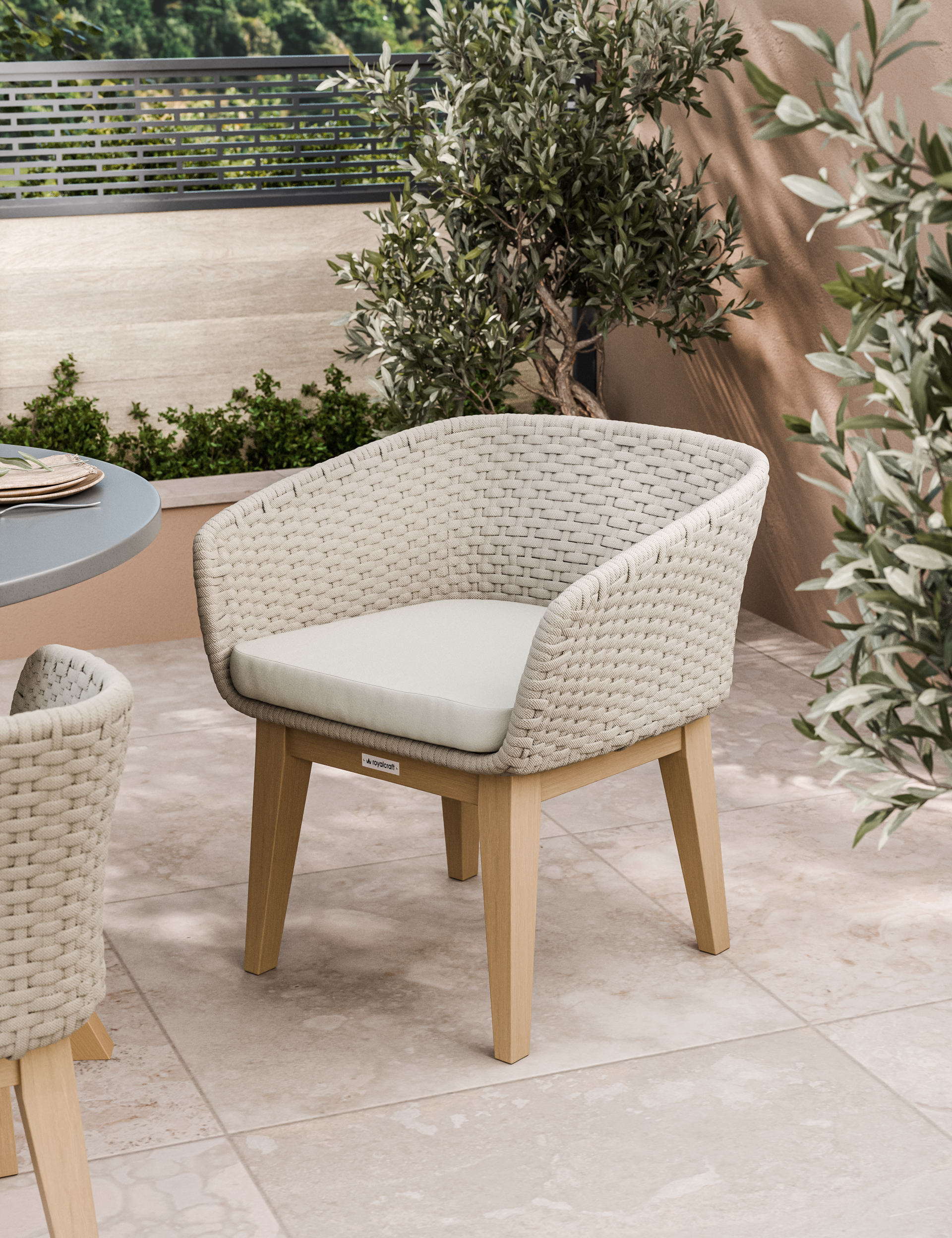 Rectangular outdoor dining table with cushioned chairs set on a patio beside garden plants