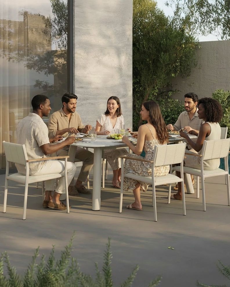 Image of Group of people dining outdoors at a modern table with greenery in the background