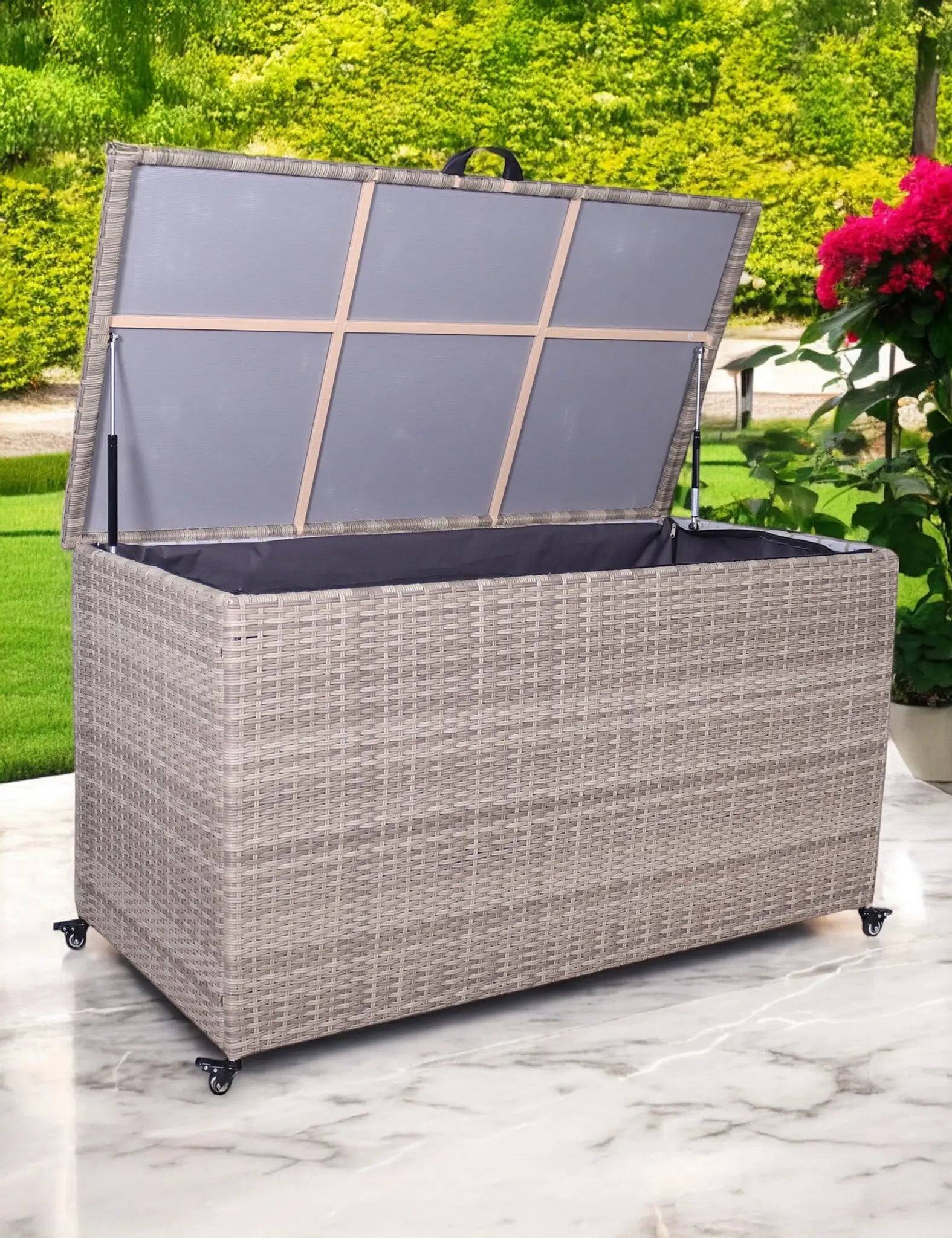 Light grey rattan outdoor storage box with open lid on patio