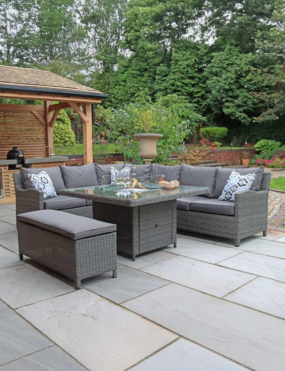 Grey rattan corner sofa set with bench and table on patio