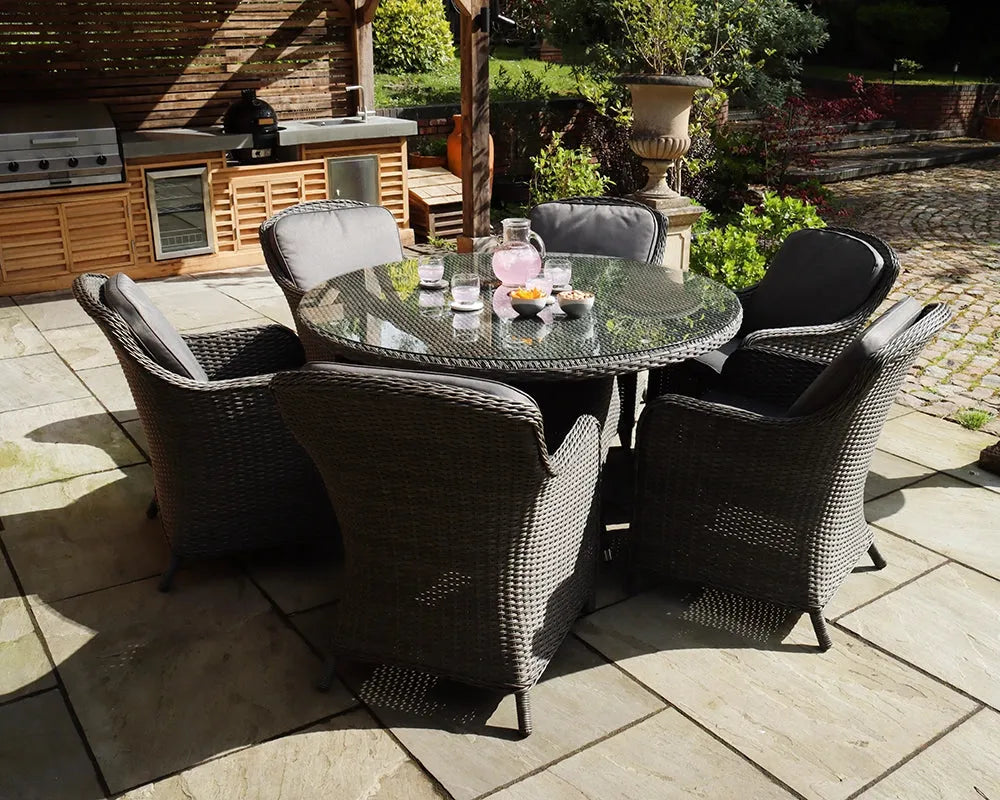 Image of Grey rattan outdoor dining set with round glass-top table and six chairs