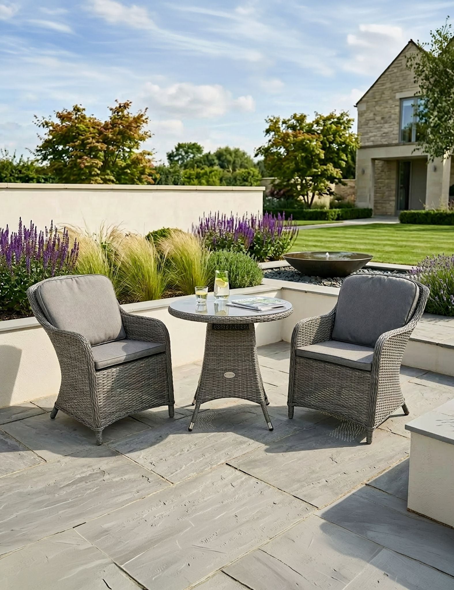 Image of Outdoor patio set with two chairs and a table in a garden setting.