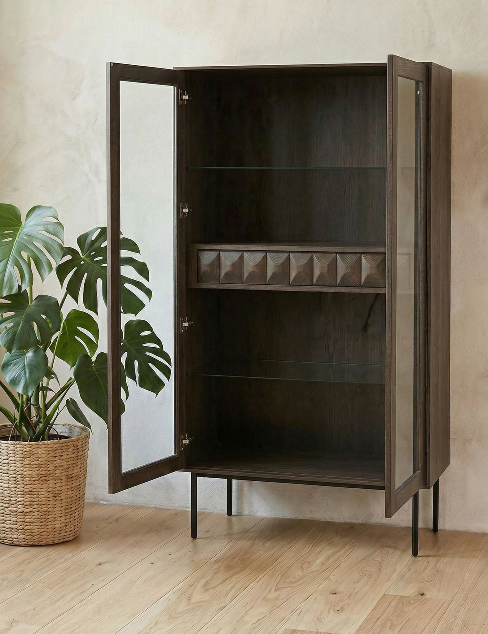 Image of Wooden cabinet with open doors in a room with a plant and wooden floor.