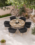 Round patio table with six black cushioned chairs set for dining