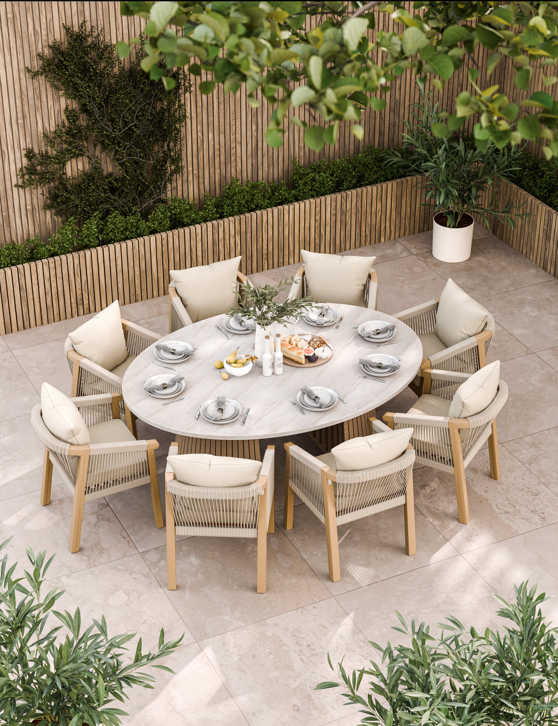 Large oval outdoor dining table with eight cream cushioned chairs