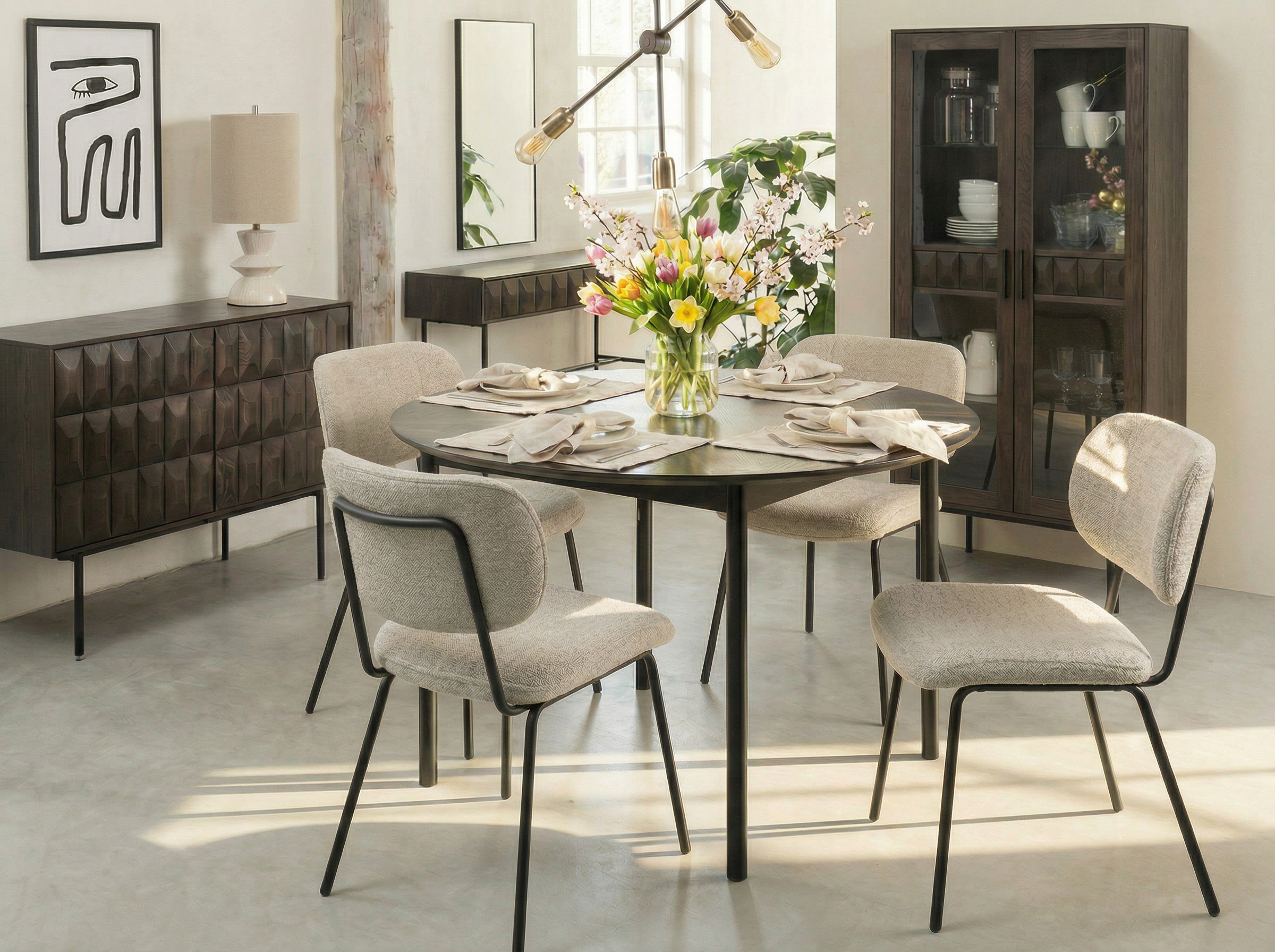 Image of Dining room with a table set for four, surrounded by chairs and decorated with flowers.