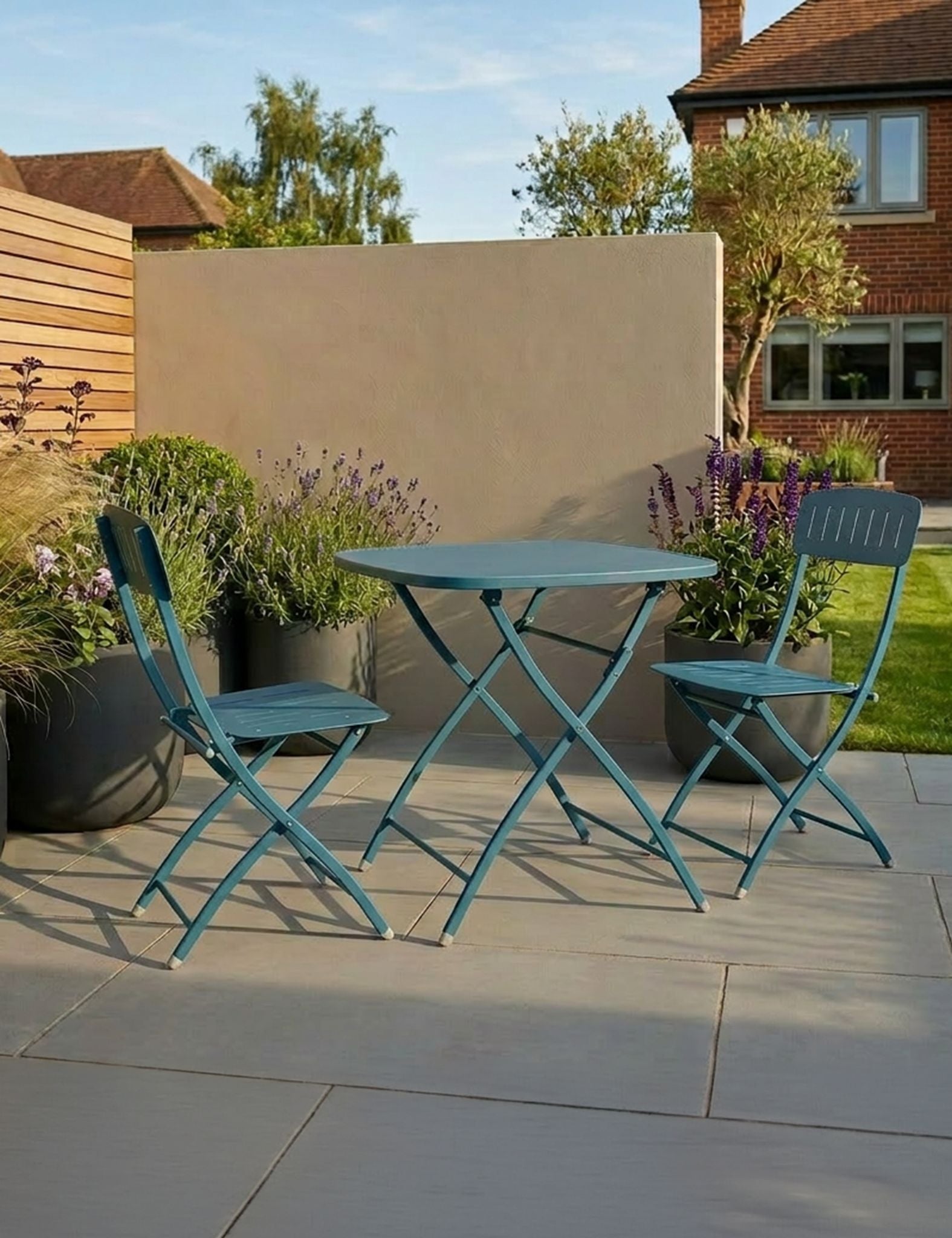 Image of outdoor table and chairs on a patio with garden and house in the background