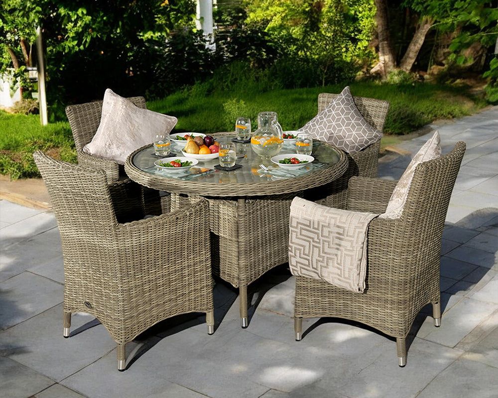 Image of Rattan dining set with round glass-top table and four cushioned chairs