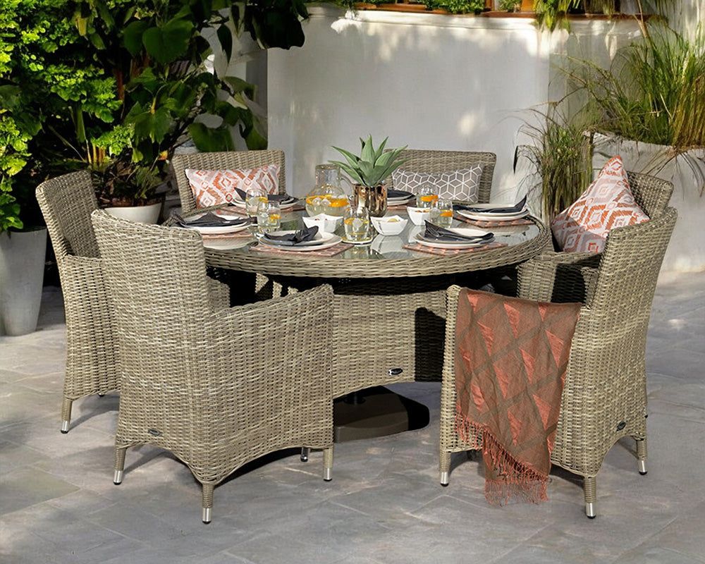 Image of Outdoor dining set with round table and chairs on a patio, surrounded by plants.