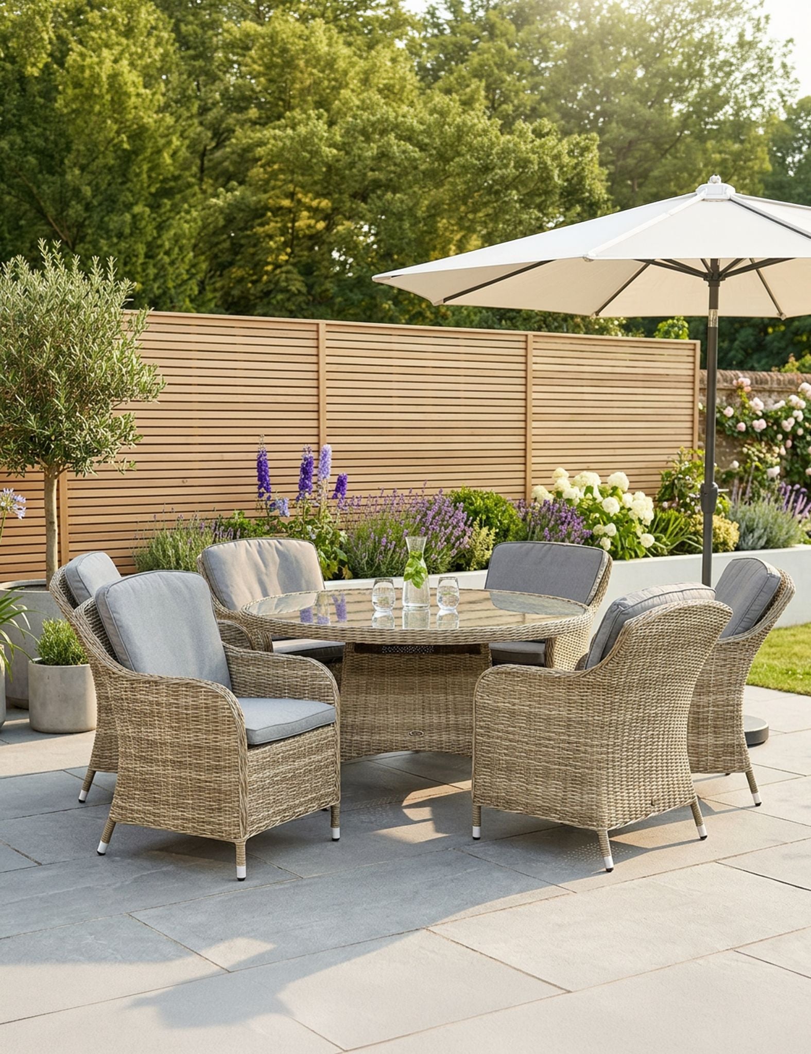 Image of Outdoor patio set with wicker chairs, table, and umbrella on a stone patio.